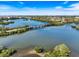 An aerial shot of the lagoon depicts a foot bridge, islands, and surrounding vegetation at 1298 Highland Greens Dr, Venice, FL 34285