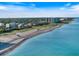 An aerial view of the coastline shows the shoreline, beach, and ocean on a sunny day at 1298 Highland Greens Dr, Venice, FL 34285