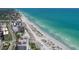 An aerial perspective shows the beach with condos and resorts nearby the blue ocean water at 1298 Highland Greens Dr, Venice, FL 34285