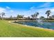 Beautiful community entrance with a serene water feature and lush landscaping, under a clear blue sky at 1298 Highland Greens Dr, Venice, FL 34285