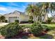 Beautiful single-story home with lush landscaping, palm trees, and a two-car garage at 1298 Highland Greens Dr, Venice, FL 34285