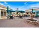 Outdoor seating area with tables, umbrellas, and a fountain at 1298 Highland Greens Dr, Venice, FL 34285