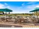 Outdoor seating area with tables and umbrellas overlooking the golf course at 1298 Highland Greens Dr, Venice, FL 34285