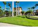 Beautiful clubhouse with lush landscaping, palm trees, and manicured lawn at 13238 Famiglia Dr, Venice, FL 34293