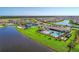 Aerial view featuring tennis courts, community pool, and scenic lake views at 13278 Huerta St, Venice, FL 34293