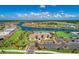 Aerial view of a community clubhouse, pool, parking, and scenic water view at 13278 Huerta St, Venice, FL 34293