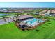 Aerial shot showcases the pool, clubhouse, and lush landscaping in this stunning lakeside community at 13278 Huerta St, Venice, FL 34293