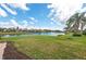 Scenic backyard view with lush green lawn and a tranquil lake at 13278 Huerta St, Venice, FL 34293