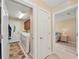Hallway view to the laundry room with a white washer and dryer and access to a cozy bedroom at 13278 Huerta St, Venice, FL 34293