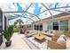 Relaxing screened-in patio with comfortable seating, perfect for outdoor entertainment and enjoying the serene backyard view at 13278 Huerta St, Venice, FL 34293