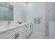 Modern bathroom with double sink vanity, framed mirrors, and marble-look glass enclosed shower at 13341 Drummond Ave, Port Charlotte, FL 33953