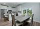 Bright dining area with a gray dining table set and view to the green backyard through sliding glass doors at 13341 Drummond Ave, Port Charlotte, FL 33953