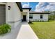 Close up of the front entrance showcasing a white exterior and minimalist landscaping at 13341 Drummond Ave, Port Charlotte, FL 33953