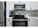 View of the kitchen appliances, including the stainless steel refrigerator, oven, and microwave oven at 13341 Drummond Ave, Port Charlotte, FL 33953