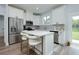 Modern kitchen featuring stainless steel appliances, white cabinetry, a large island, and a view to the backyard at 13341 Drummond Ave, Port Charlotte, FL 33953