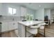 Modern kitchen with white cabinets, stainless steel appliances, and an island with seating next to the dining area at 13341 Drummond Ave, Port Charlotte, FL 33953