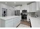 Bright, modern kitchen with white cabinetry, stainless steel appliances, and an island with a white countertop at 13341 Drummond Ave, Port Charlotte, FL 33953