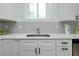 Close-up of the kitchen featuring sleek white countertops and cabinets with modern hardware at 13341 Drummond Ave, Port Charlotte, FL 33953