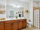 Bathroom featuring a double vanity, a large mirror, and a shower with a striped curtain at 1342 Maseno Dr, Venice, FL 34292