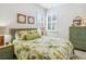Bright bedroom with large windows, plantation shutters, tropical bedding, and wood-look floors at 1342 Maseno Dr, Venice, FL 34292
