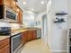 Kitchen showcasing wooden cabinetry, stainless steel appliances, and a view into the next room at 1342 Maseno Dr, Venice, FL 34292