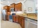 A kitchen with stainless steel appliances, wooden cabinets, granite countertops, and tile flooring at 1342 Maseno Dr, Venice, FL 34292