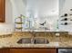 Kitchen bar top with granite countertop, a sink, and a view into the living room at 1342 Maseno Dr, Venice, FL 34292
