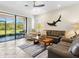 Open living room featuring a ceiling fan, a decorative shark and easy access to outdoor patio at 1342 Maseno Dr, Venice, FL 34292