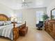 A bedroom with a wooden bed frame, a ceiling fan, plantation shutters, and tile floors at 1342 Maseno Dr, Venice, FL 34292