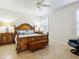 A bedroom with a wooden bed frame, a ceiling fan, plantation shutters, and tile floors at 1342 Maseno Dr, Venice, FL 34292