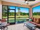 Screened lanai with comfortable seating and a peaceful view of the well maintained backyard at 1342 Maseno Dr, Venice, FL 34292