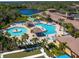 Aerial view of the community pool area featuring multiple pools, seating, landscaping, and a pond at 1342 Maseno Dr, Venice, FL 34292