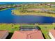 Aerial view of a screened pool, a terracotta roof, and a lake at 13730 Vancanza, Venice, FL 34293