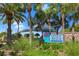 Welcoming entrance to Venice Beach, framed by palm trees and lush greenery, inviting visitors to relax and enjoy at 13730 Vancanza, Venice, FL 34293