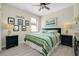 Cozy bedroom featuring a ceiling fan, an art piece, and black nightstands at 13730 Vancanza, Venice, FL 34293