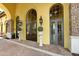 Welcoming clubhouse entrance with decorative planters, exterior lighting, and large arched windows and doors at 13730 Vancanza, Venice, FL 34293