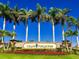 Beautiful Gran Paradiso community sign featuring vibrant landscaping, mature palms, and bright blue sky at 13730 Vancanza, Venice, FL 34293
