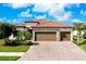 Beautiful single-Gathering home featuring a red tile roof, three-car garage, and a paved driveway at 13730 Vancanza, Venice, FL 34293