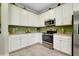 Bright kitchen with white cabinets and stainless steel appliances at 13730 Vancanza, Venice, FL 34293