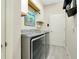 Laundry room featuring modern gray machines and white walls at 13730 Vancanza, Venice, FL 34293