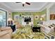 A living room is styled with a palm rug, a wall unit, recliners, and a green accent wall at 13730 Vancanza, Venice, FL 34293
