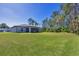 Sprawling backyard with well-maintained lawn and view of the home at 1449 Overhead St, North Port, FL 34288