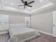 Neutral bedroom featuring a tray ceiling with fan, hardwood floors, and ample natural light at 1449 Overhead St, North Port, FL 34288