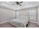 Cozy bedroom featuring a tray ceiling with ceiling fan, and natural light from the windows at 1449 Overhead St, North Port, FL 34288