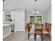 Bright dining room featuring a modern chandelier, dining set, and sliding glass doors leading to outdoor views at 1449 Overhead St, North Port, FL 34288