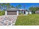 Beautiful single-story home with a two-car garage and colorful, patterned driveway at 1449 Overhead St, North Port, FL 34288