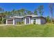 Charming single-story home with a two-car garage and manicured lawn at 1449 Overhead St, North Port, FL 34288