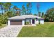 Single-story home with a paved driveway, a two-car garage, and a cozy front entrance at 1449 Overhead St, North Port, FL 34288