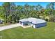 Features include a two-car garage, light gray stucco, and patterned paved driveway at 1449 Overhead St, North Port, FL 34288