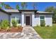 Charming home featuring a decorative front door and colorful landscaping at 1449 Overhead St, North Port, FL 34288